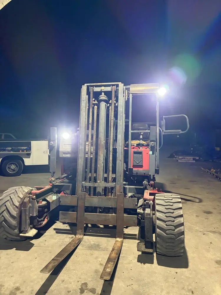 Rough-terrain forklift lit up during after-hours mobile service in Southwest Florida