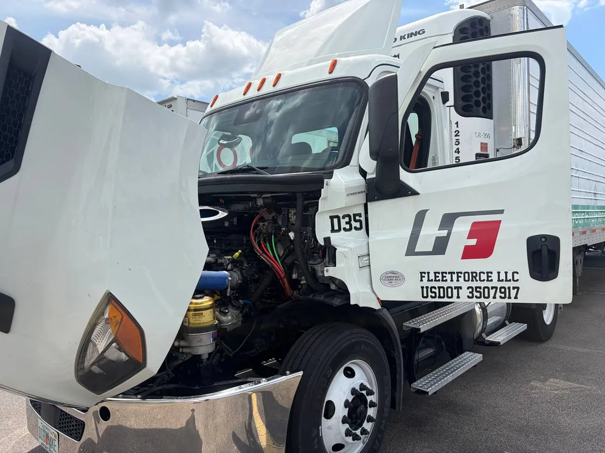 Freightliner Cascadia day cab with the hood open for diesel truck repair