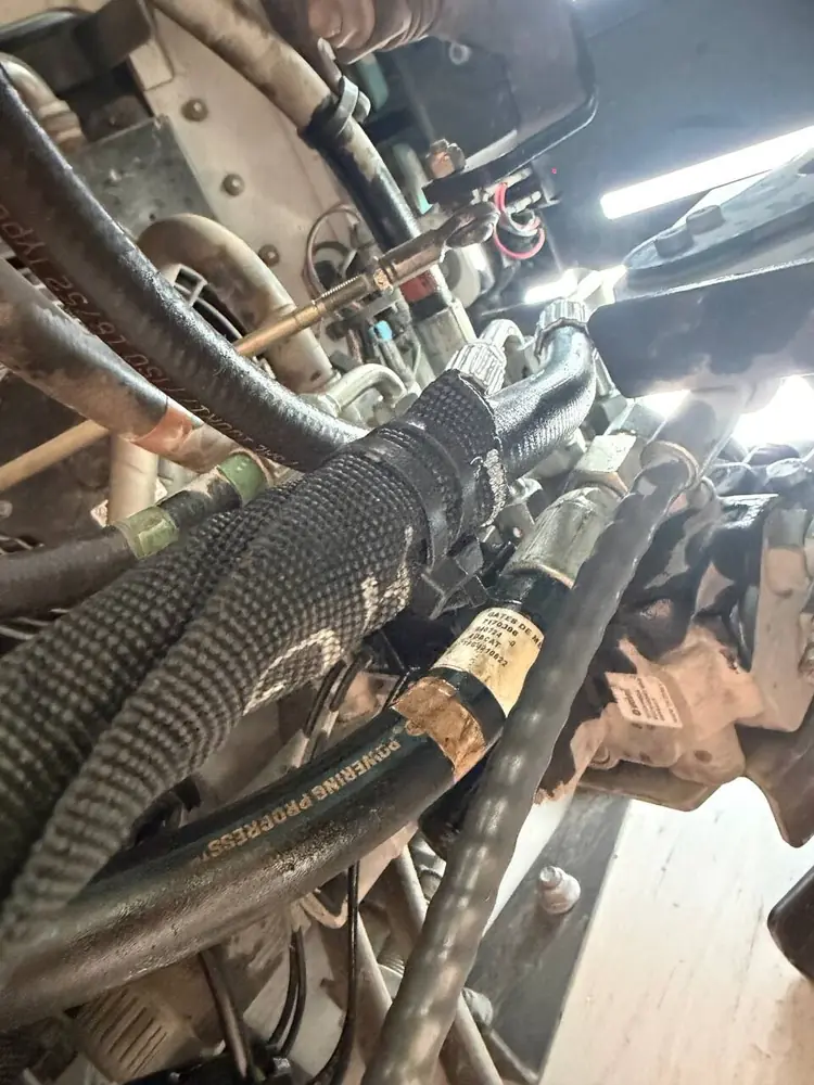 Close-up of power steering hoses and lines during a mobile truck repair