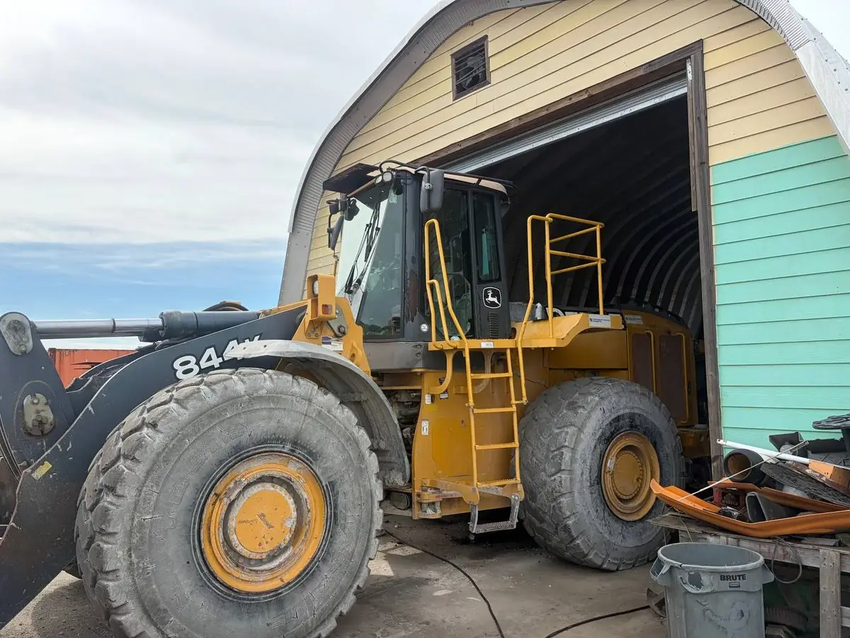 John Deere 844 wheel loader parked at an equipment barn