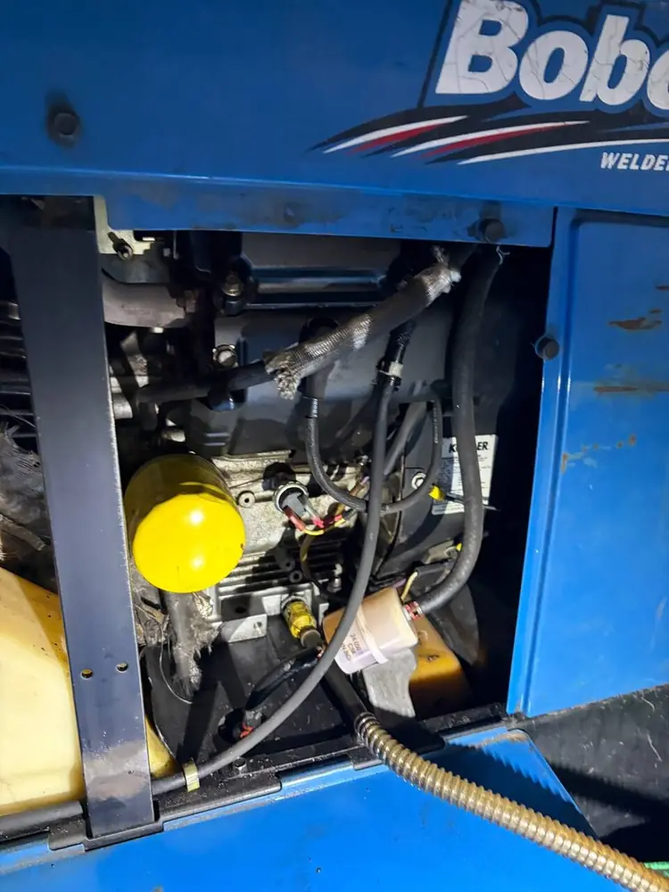 Kohler engine inside a Miller welder generator during an on-site welder repair